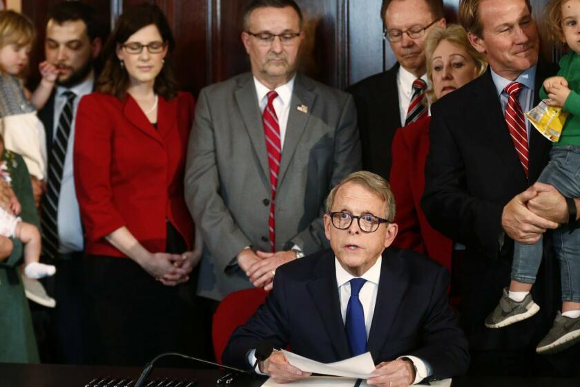 Gov. Mike DeWine speaks before signing a bill imposing one of the nation's toughest abortion restrictions, Thursday, April 11, 2019 in Columbus, Ohio. DeWine's signature makes Ohio the fifth state to ban abortions after the first detectable fetal heartbeat. That can come as early as five or six weeks into pregnancy, before many women know they're pregnant. (Fred Squillante/The Columbus Dispatch via AP)