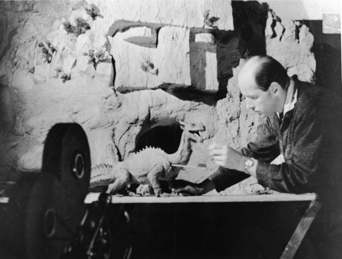 Ray Harryhausen, best known for his stop-motion animation in "Jason and the Argonauts" and "Clash of the Titans," works with a figure of a dinosaur as a camera rolls in 1965.