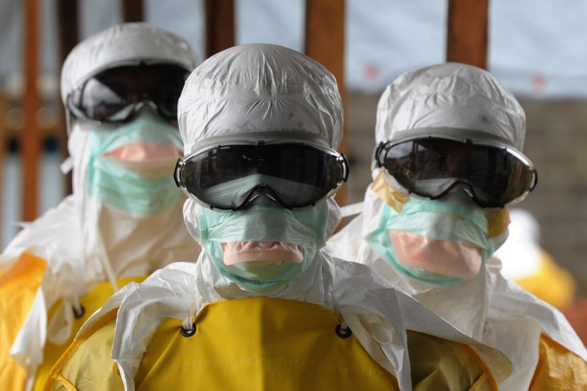 Healthcare workers in protective suits leave the high-risk area of a Doctors Without Borders Ebola treatment facility in Monrovia, Liberia, in August. A panel of experts says the outbreak exposed the World Health Organization's organizational failings.