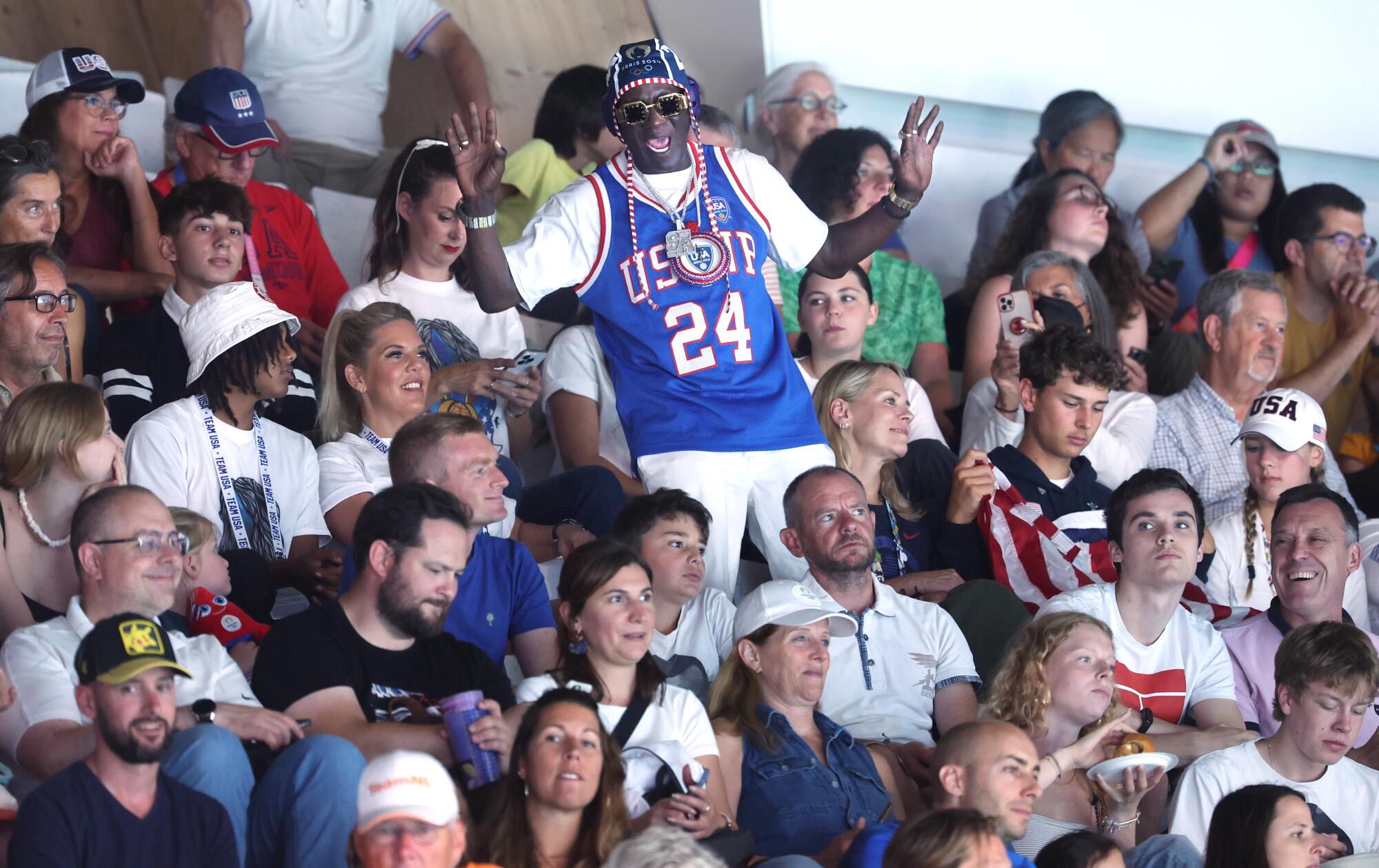 Rapper Flavor Flav cheers in the stands for the USA team during a water polo match against Greece.