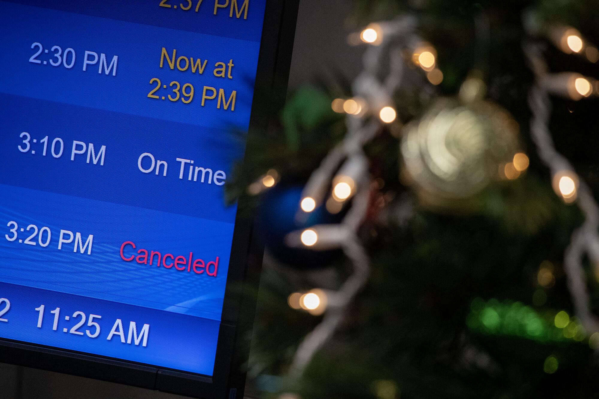 Canceled and delayed flights posted on a digital flat screen.