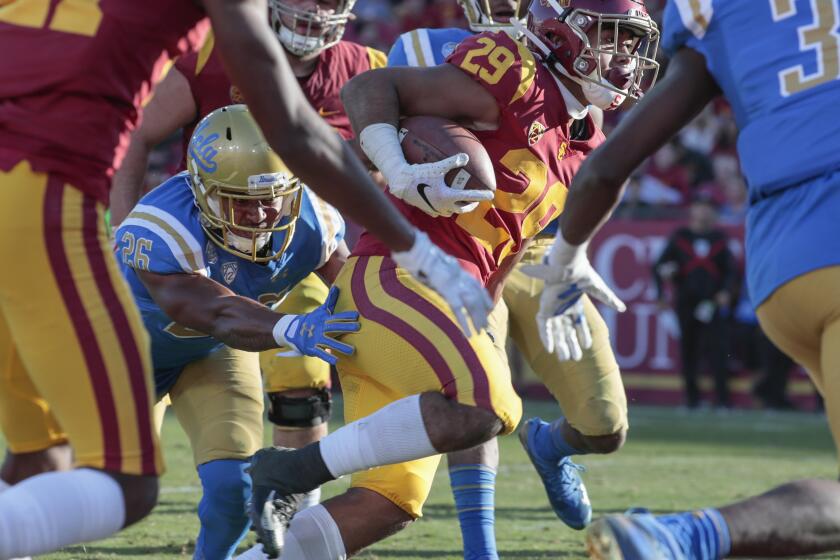 LOS ANGELES, CA, SATURDAY, NOVEMBER 23, 2019 - USC Trojans running back Vavae Malepeai (29) eludes the tackle of DUPLICATE***UCLA Bruins linebacker Leni Toailoa (26) for a third quarter touchdown run at the Coliseum. (Robert Gauthier/Los Angeles Times)