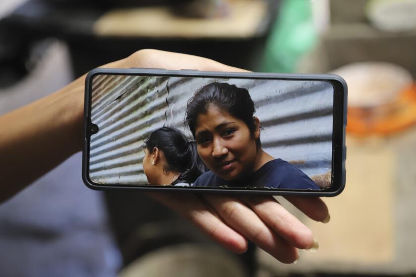 A family member shows a phone photo of Juana Guadalupe Recinos, who was detained last year during the government's crackdown on its war against drugs, in Santa Ana, El Salvador, Wednesday, Jan. 31, 2024. Police detained Recinos on a charge of “illegal gathering” as she walked to work leaving her two sons motherless for more than a year. (AP Photo/Salvador Melendez)