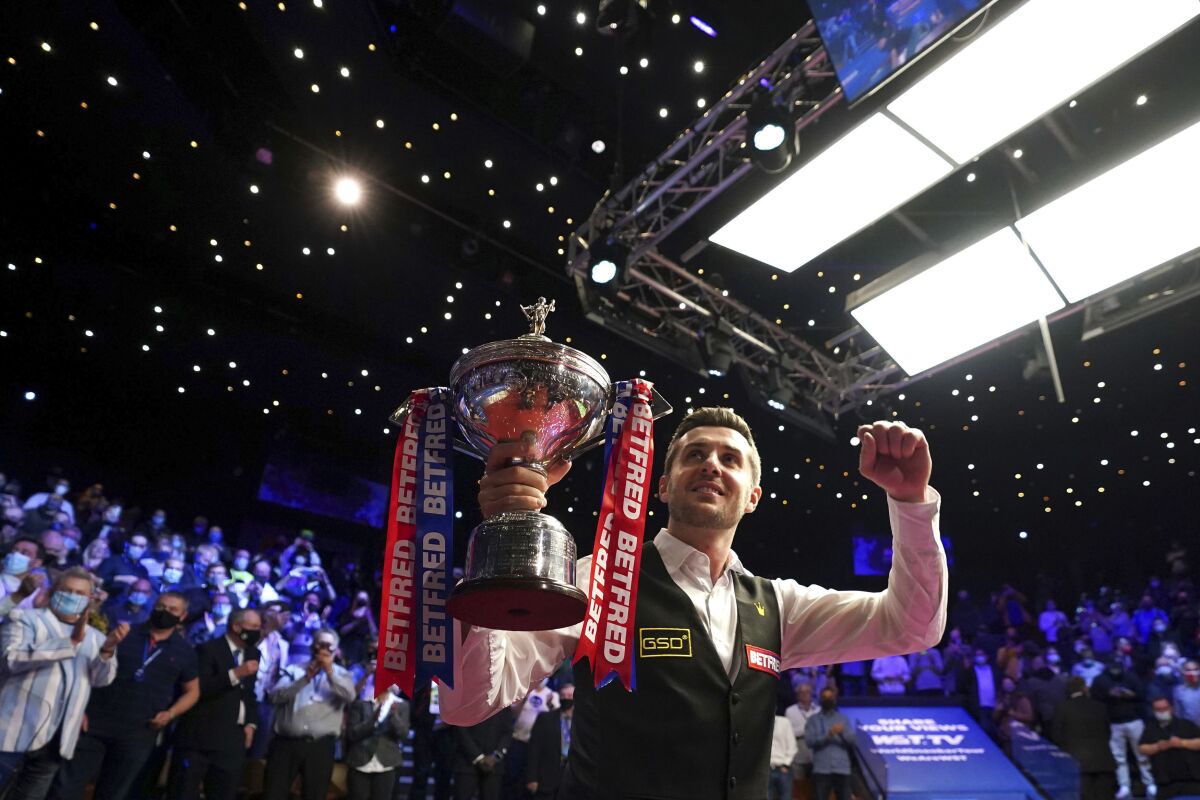 England's Mark Selby celebrates with his trophy after winning the World Snooker Championships at the Crucible Theatre in Sheffield, England, Monday, May 3, 2021. (Zac Goodwin/PA via AP)