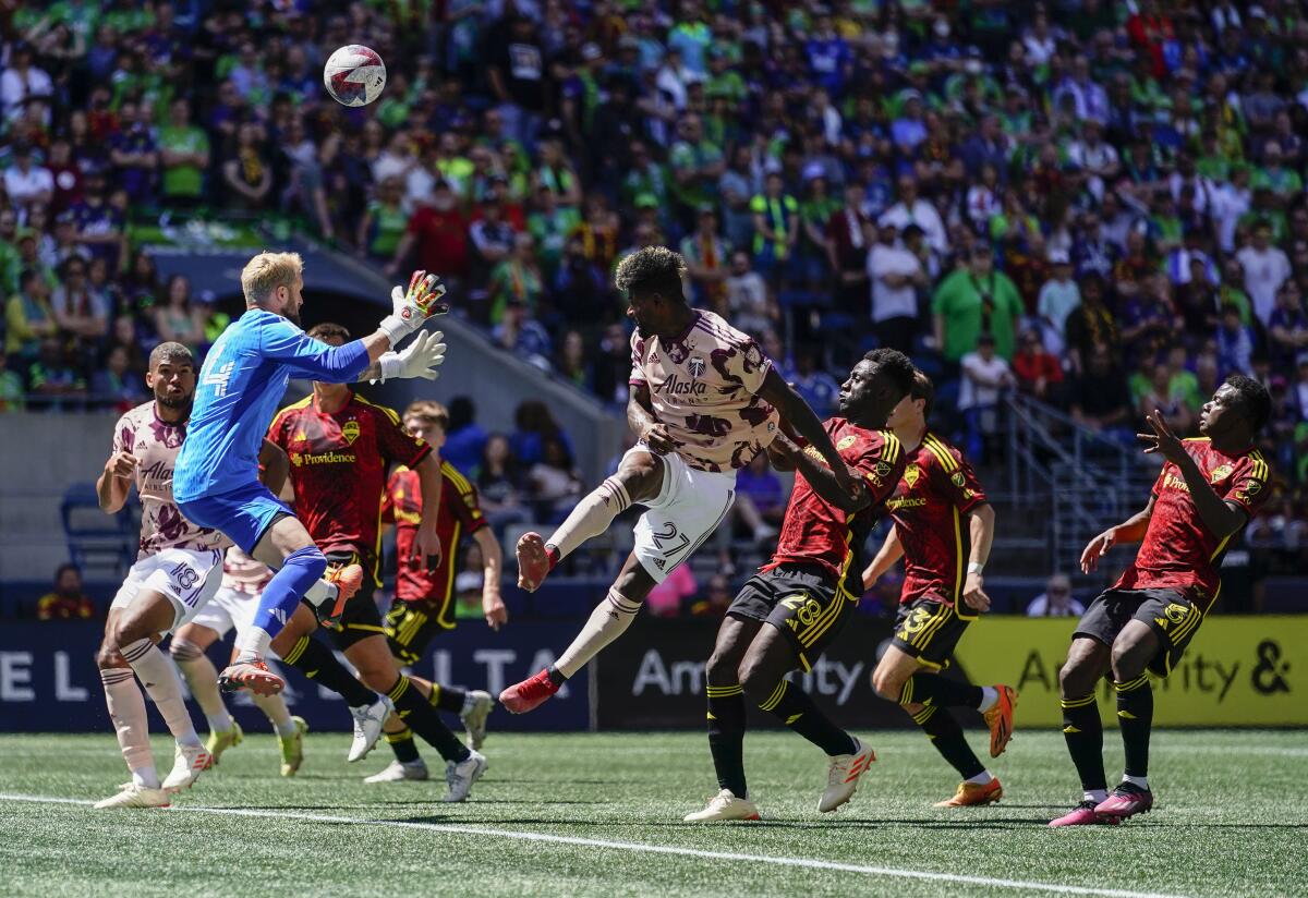 Seattle Sounders goalkeeper Stefan Frei, left, goes up to defend against Portland Timbers forward Dairon Asprilla (27) during a free kick during the first half of an MLS soccer match, Saturday, June 3, 2023, in Seattle. (AP Photo/Lindsey Wasson)