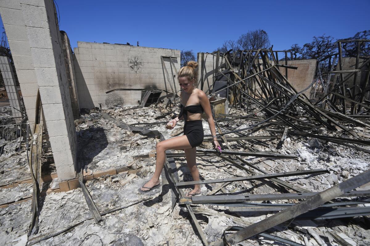 Sydney Carney walks through her former home, which was destroyed by a wildfire.
