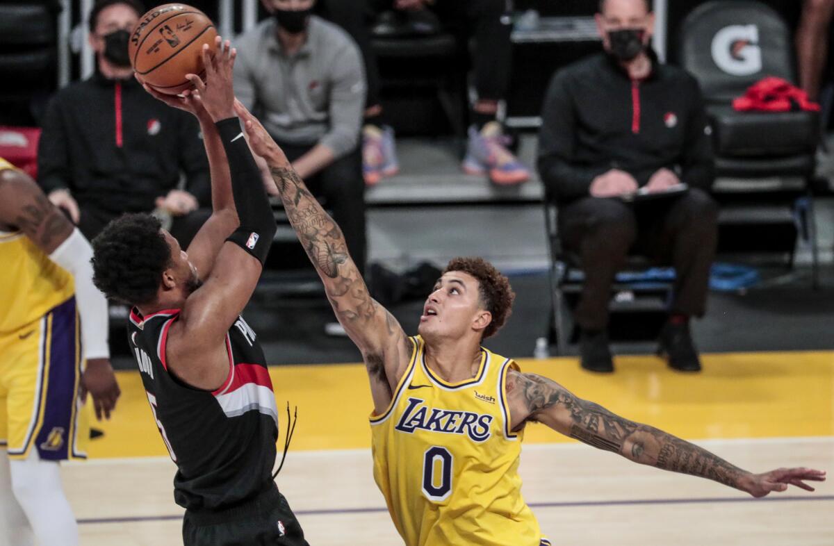 Lakers forward Kyle Kuzma tries to block the shot of Portland Trail Blazers guard Rodney Hood.