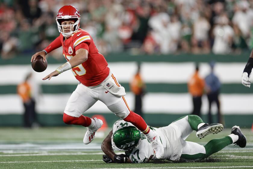Patrick Mahomes (15), quarterback de los Chiefs de Kansas City, es tropezado por el linebacker de los Jets de Nueva York, Bryce Huff (47), mientras lanza un pase durante el segundo cuarto del partido de la NFL, el domingo 1 de octubre de 2023, en East Rutherford, Nueva Jersey. (AP Foto/Adam Hunger)