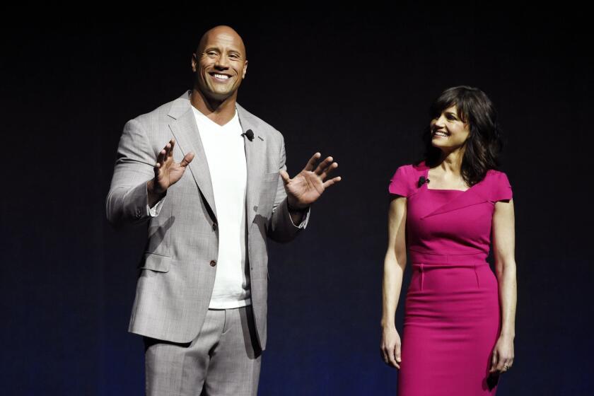 Dwayne Johnson, a cast member in the upcoming film "San Andreas," and fellow cast member Carla Gugino introduce a clip from the film during CinemaCon 2015.