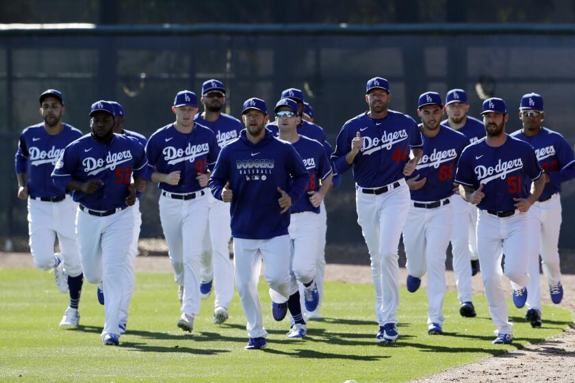 Los Angeles Dodgers pitchers warm up during spring training baseball Friday, Feb. 14, 2020, in Phoenix. (AP Photo/Gregory Bull)