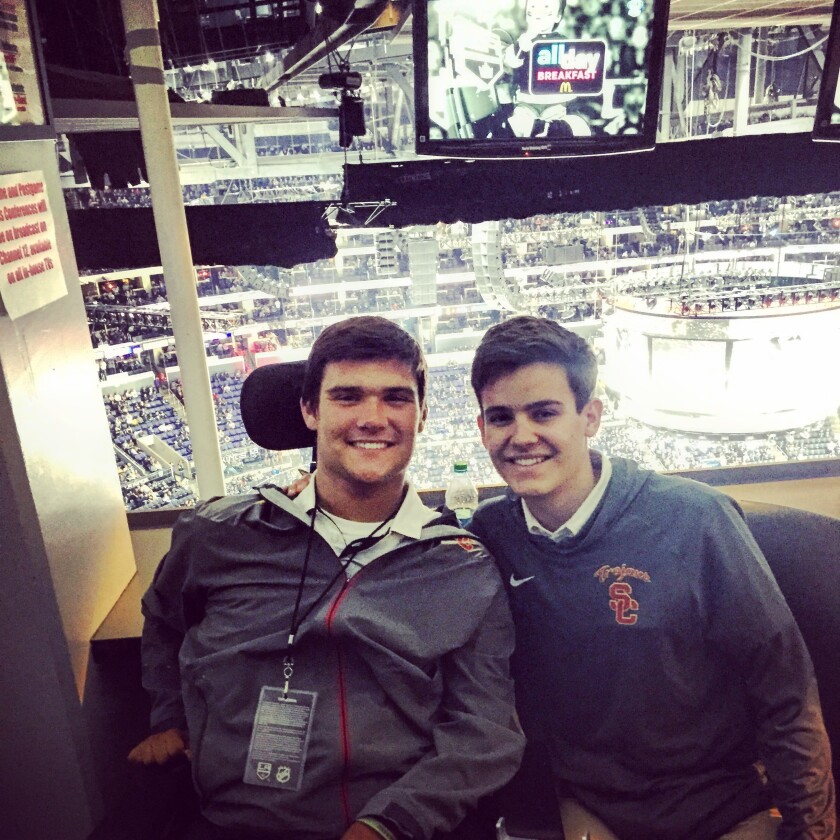 Jack Jablonski, left, and his brother Max sit together in an arena.