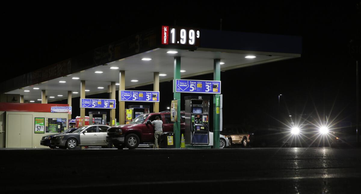 Motorists purchase gas at a station that dropped the unleaded fuel price to $1.99 per gallon on Aug. 16 in San Antonio.