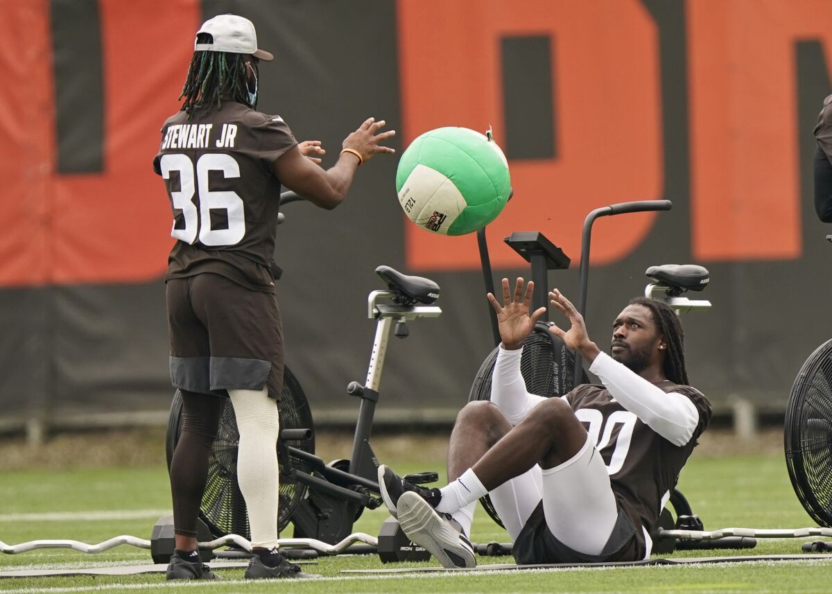 Cleveland Browns linebacker Jadeveon Clowney, right, and cornerback M.J. Stewart run drills during practice at the NFL football team's training camp facility, Tuesday, Aug. 17, 2021, in Berea, Ohio. (AP Photo/Tony Dejak)