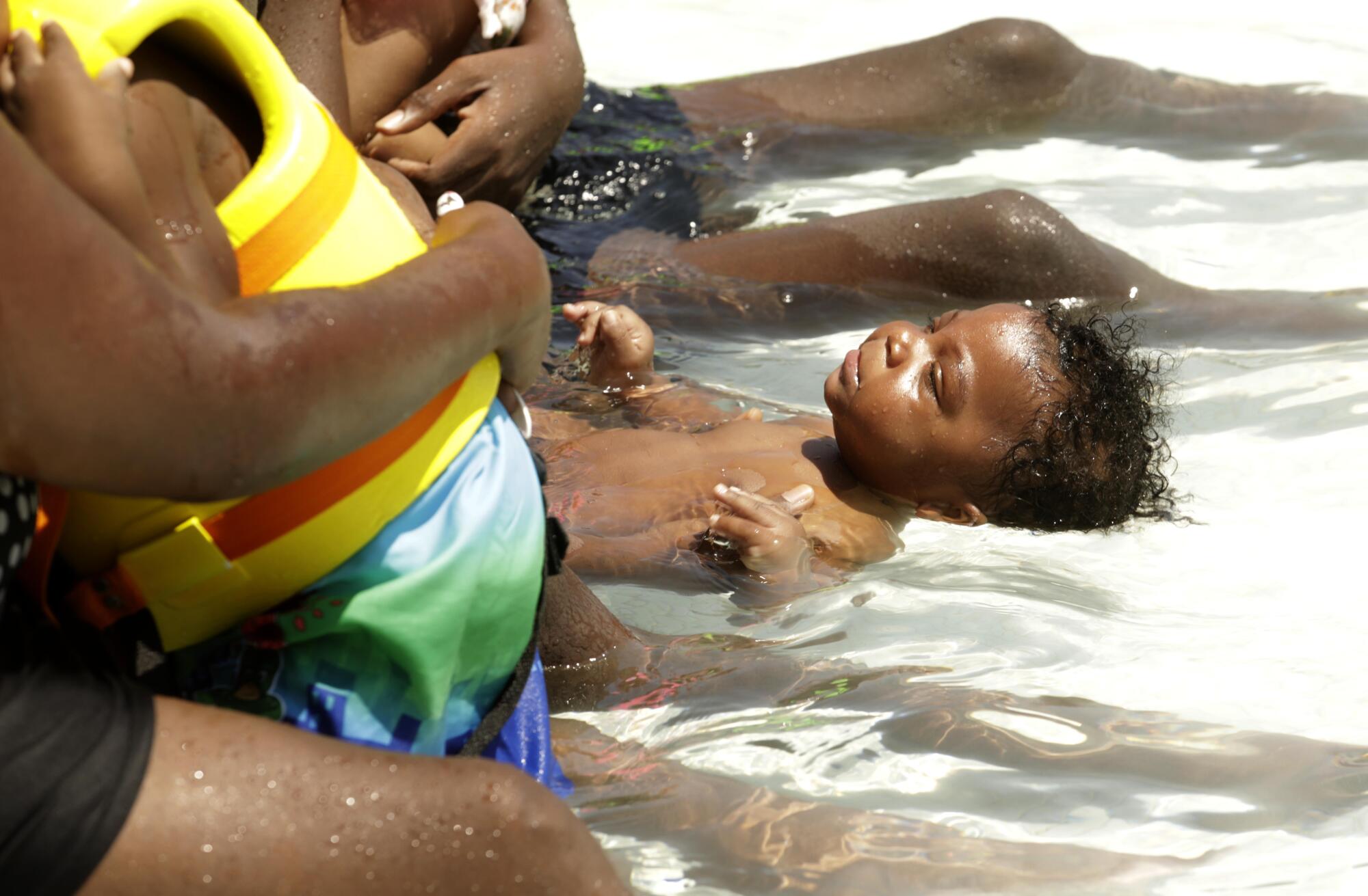 Antwan Council, cools off with the help of his uncle James Mejia while visiting Dry Town Water Park.