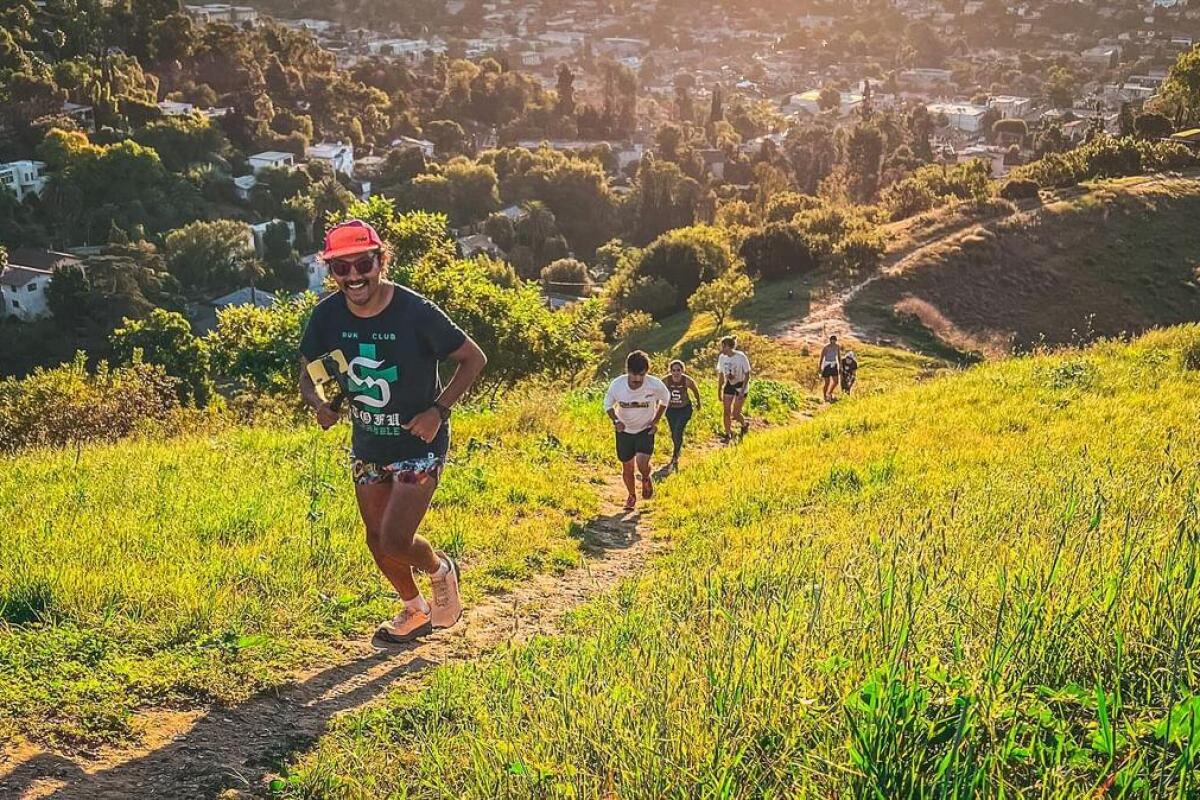 Runners head up a hillside trail