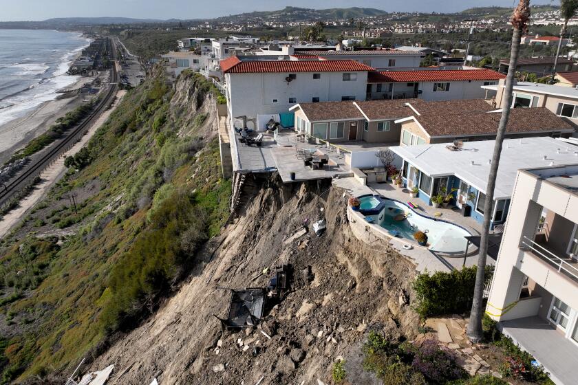 San Clemente, CA - March 16: Aerial view of four cliff-side, ocean-view apartment buildings that were evacuated and red tagged after heavy rains brought on a landslide that left the rear of the buildings in danger of tumbling down the cliff on Buena Vista in San Clemente Thursday, March 16, 2023. (Allen J. Schaben / Los Angeles Times)
