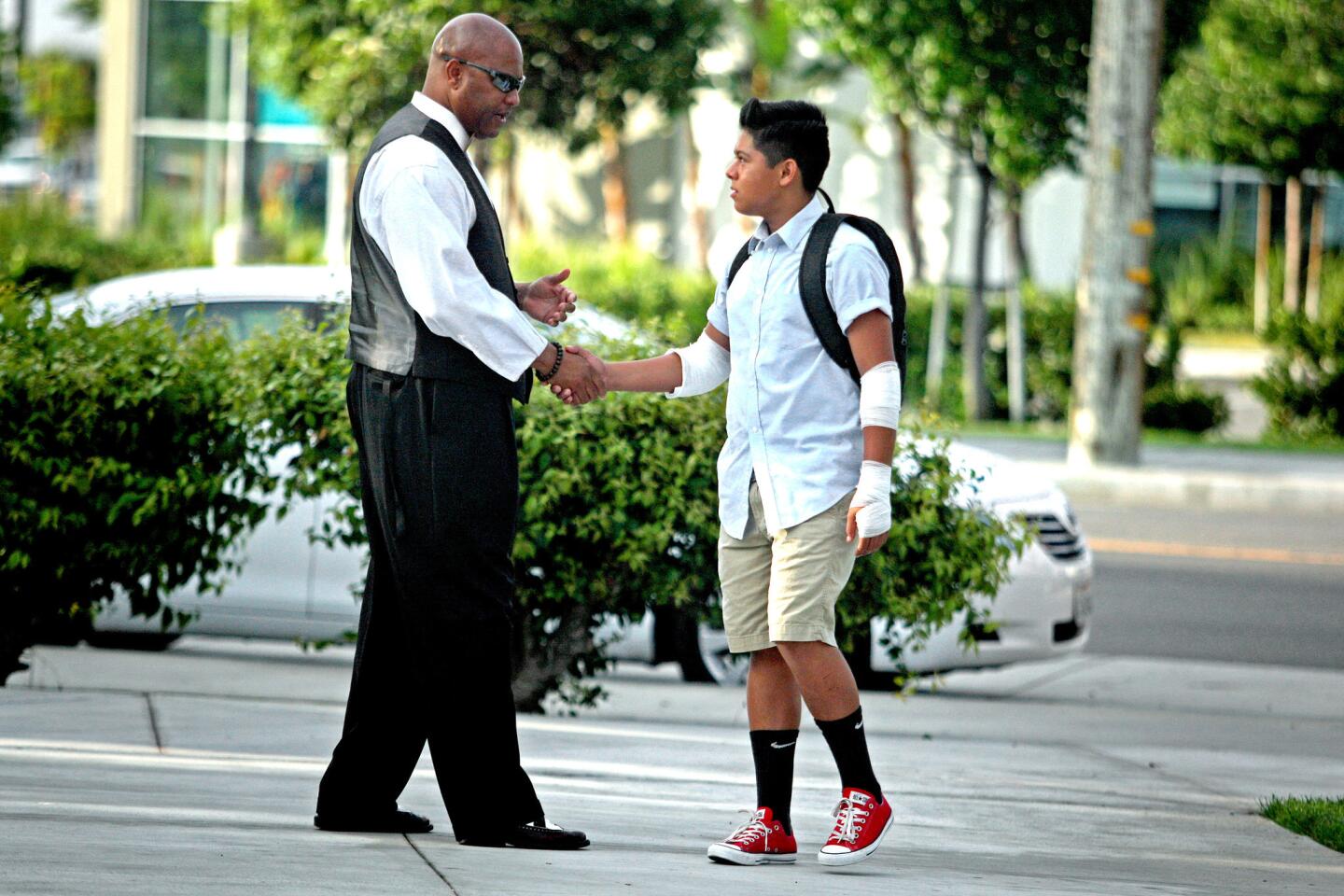 Principal Todd Irving, left, greets Isaac Martinez, 13, before school starts at Spurgeon Intermediate School in Santa Ana.