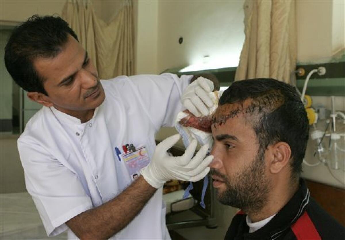 A doctor examines Imad Abdullah, 25, who was injured in a car bomb attack in Baghdad, Iraq, Tuesday, Dec. 15, 2009. A series of car bombs ripped through downtown Baghdad near the heavily fortified Green Zone. (AP Photo/Adil al-Khazali)