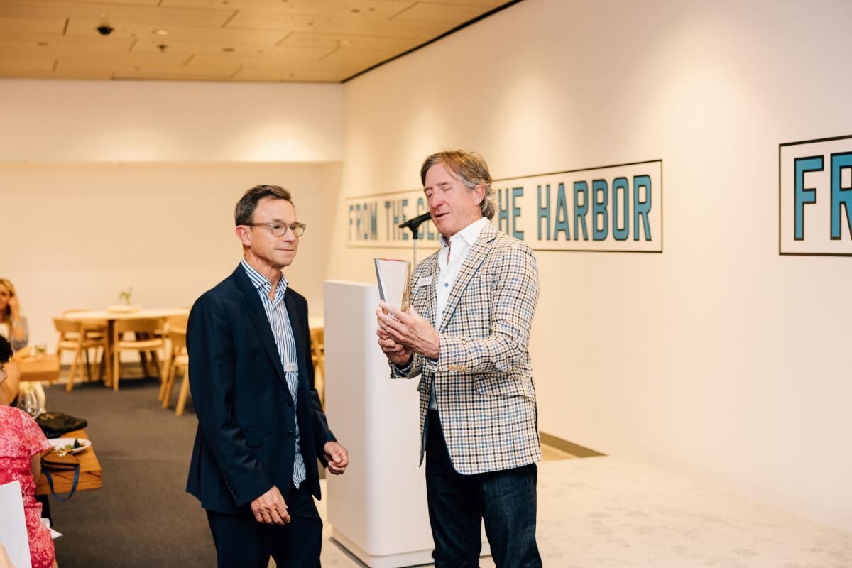 David Emmes, president of the OCMA board of trustees, presents John Gunnin with an award.