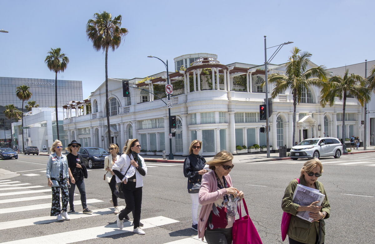 Pedestrians walk past a building at the intersection of Rodeo Drive and Santa Monica Blvd.