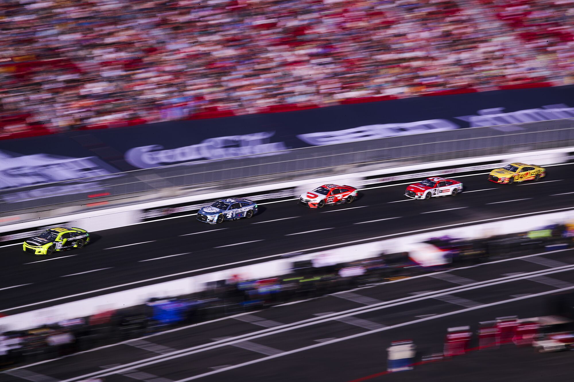 The pack of cars race around the quarter-mile track at the Coliseum.