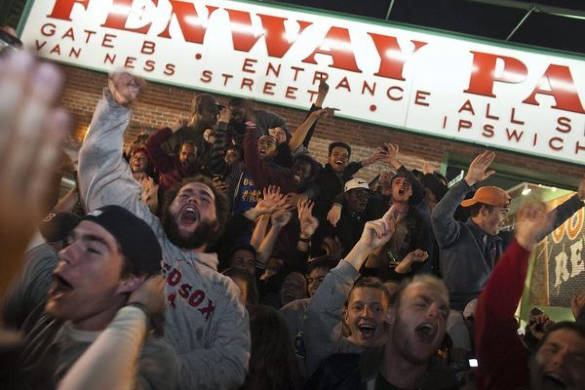 Fans rush out of Gate B after the Red Sox win Game 6 of the World Series at Fenway Park.
