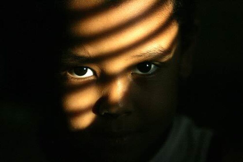Sudanese refugee Mazine Mohamed, 5, peers through the late-afternoon light from his home in Omaha. Mazine lives with his parents, Abdel Hamid Mohamed and Hayffa Ahmed, and siblings in a two-bedroom apartment.