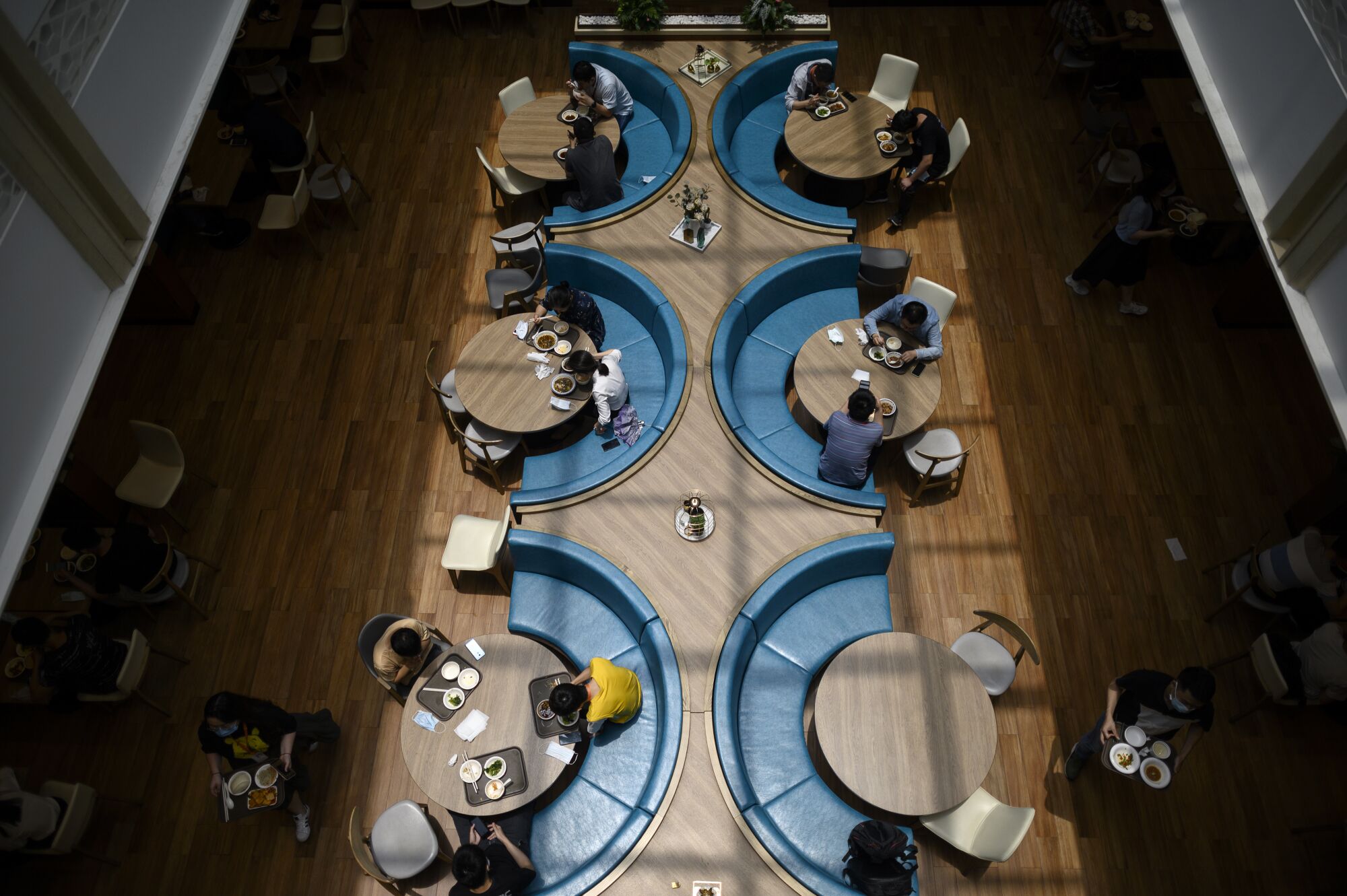 A view from above shows office workers eating lunch.