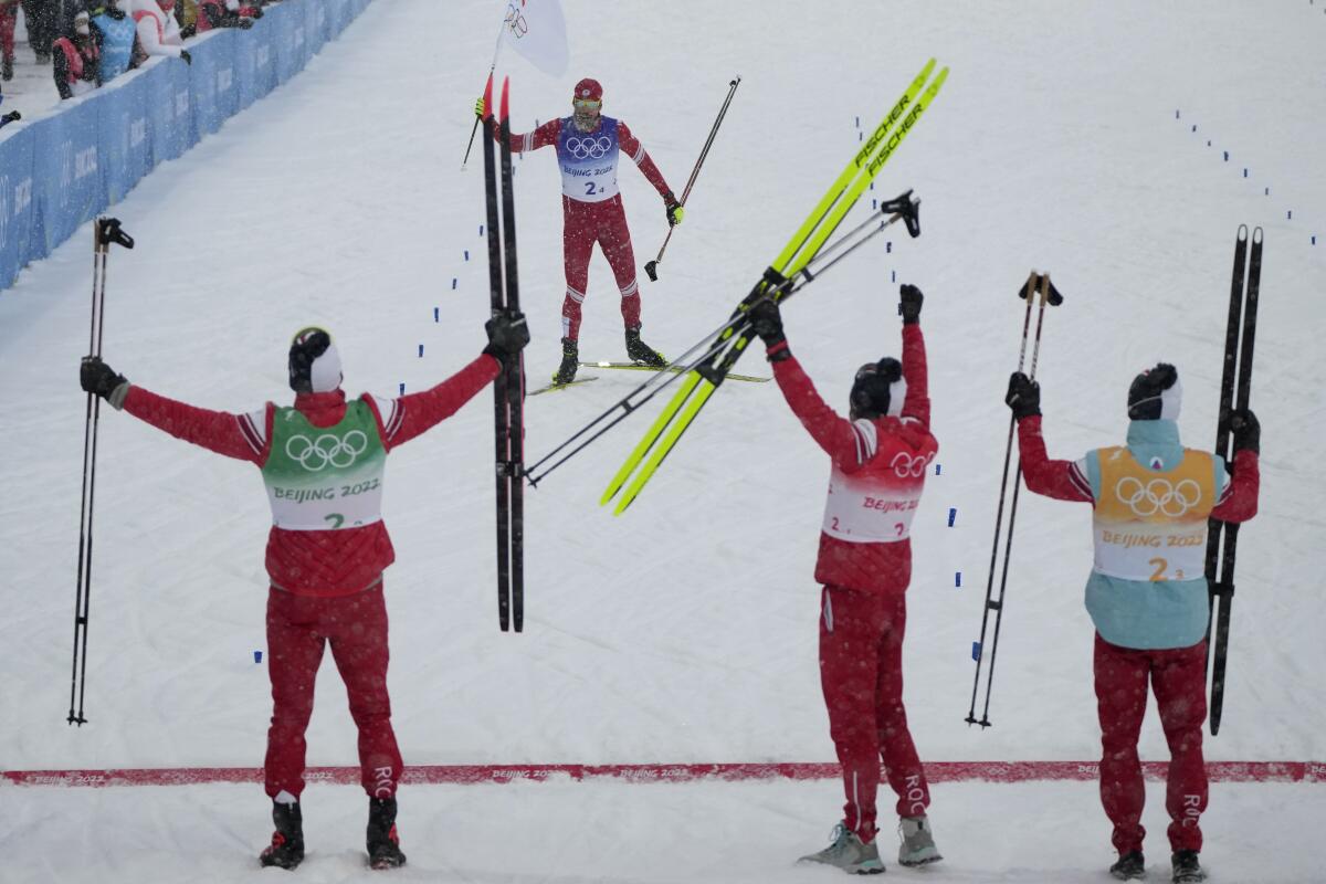 Teammates cheer as Sergey Ustiugov finishes.