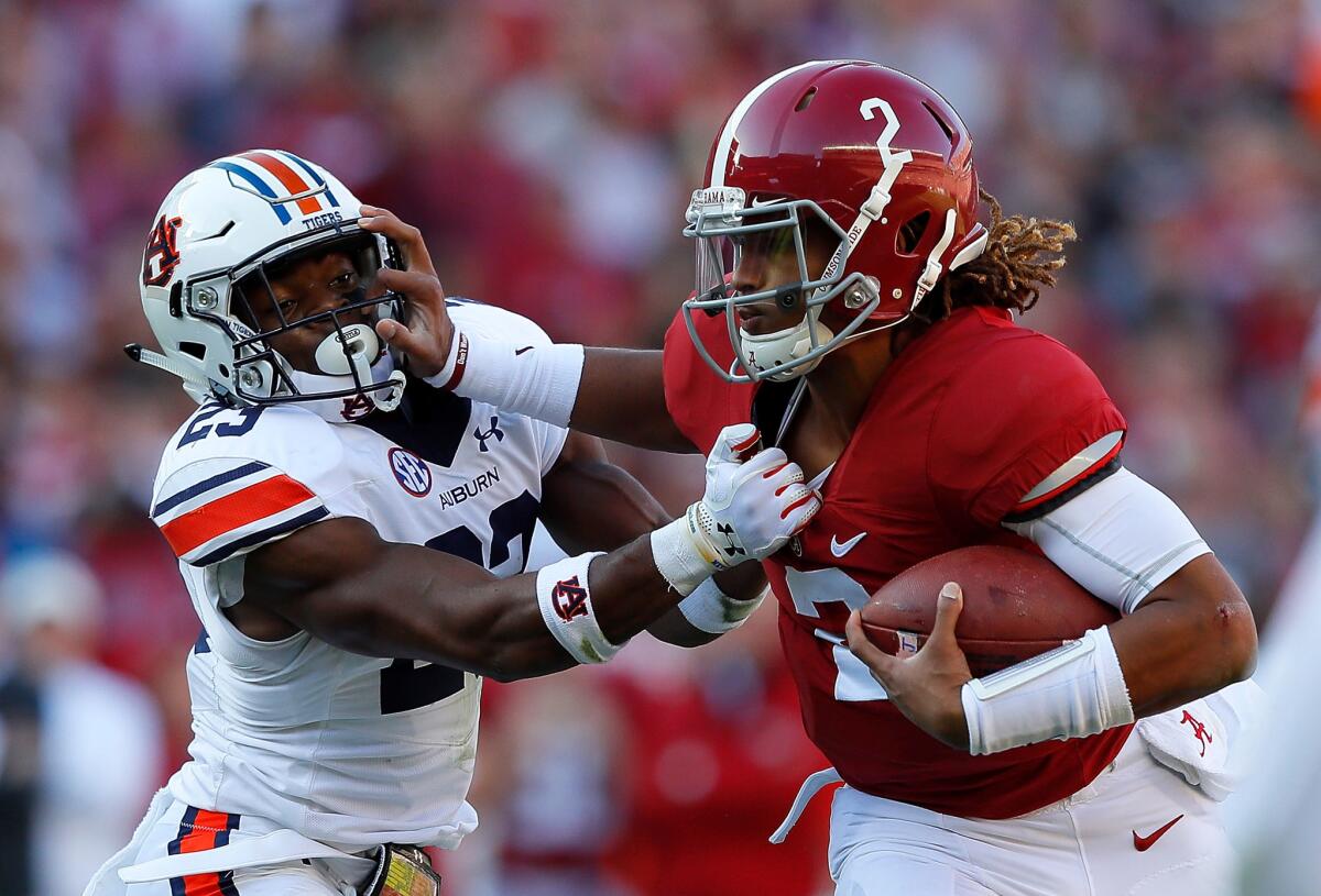 Alabama quarterback Jalen Hurts tries to break a tackle against Auburn's Johnathan Ford on Nov. 26.