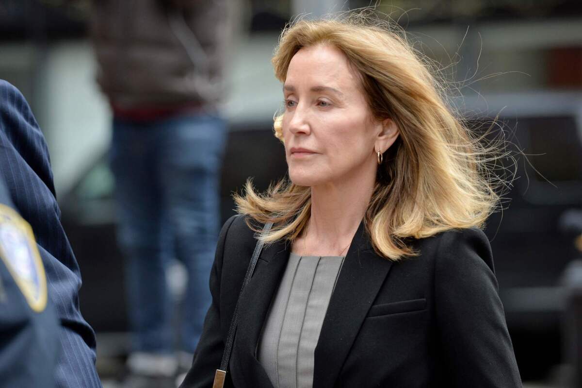 Actress Felicity Huffman is escorted by police into court in Boston on Monday.
