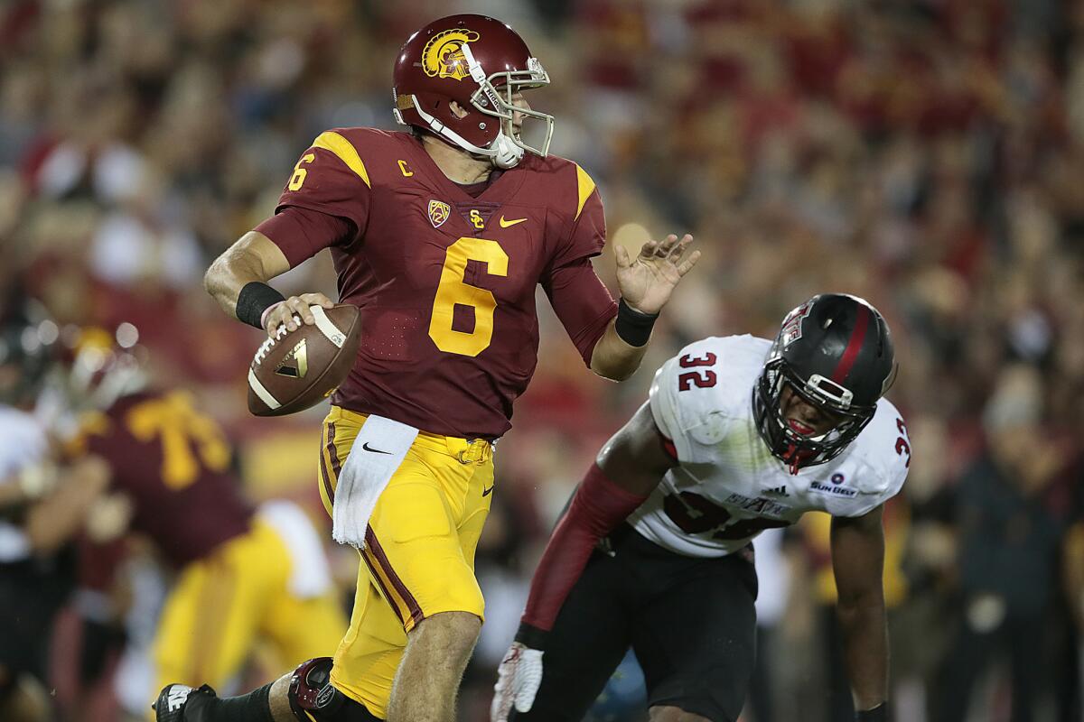 USC quarterback Cody Kessler is chased by Arkansas State linebacker Tajhea Chambers in the first quarter of their season opener on Sept. 5 at the Coliseum.