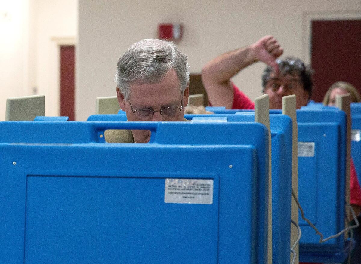 A voter gestures as Senate Minority Leader Mitch McConnell (R-Ky.) votes at Bellarmine University in Louisville.