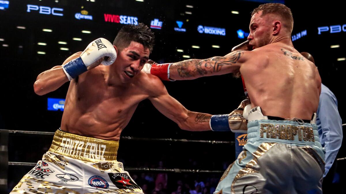 Leo Santa Cruz, left, and Carl Frampton exchange punches during their featherweight title fight on July 30. They are set for a rematch Jan. 28.