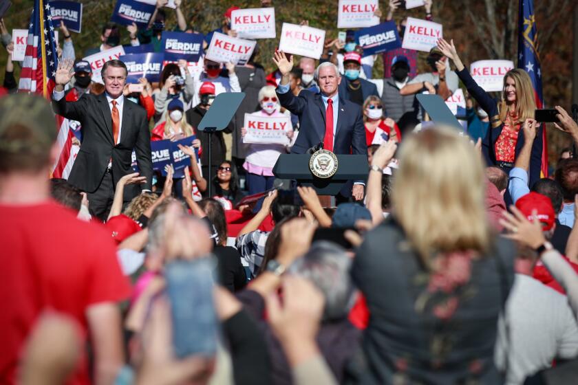 CANTON, GA - NOVEMBER 20: Vice President Mike Pence waves to supporters at a Defend the Majority Rally in Canton Georgia along with Sen. David Perdue (R-GA) and Sen. Kelly Loeffler (R-GA)on Friday, Nov. 20, 2020 in Canton, GA. (Jason Armond / Los Angeles Times)