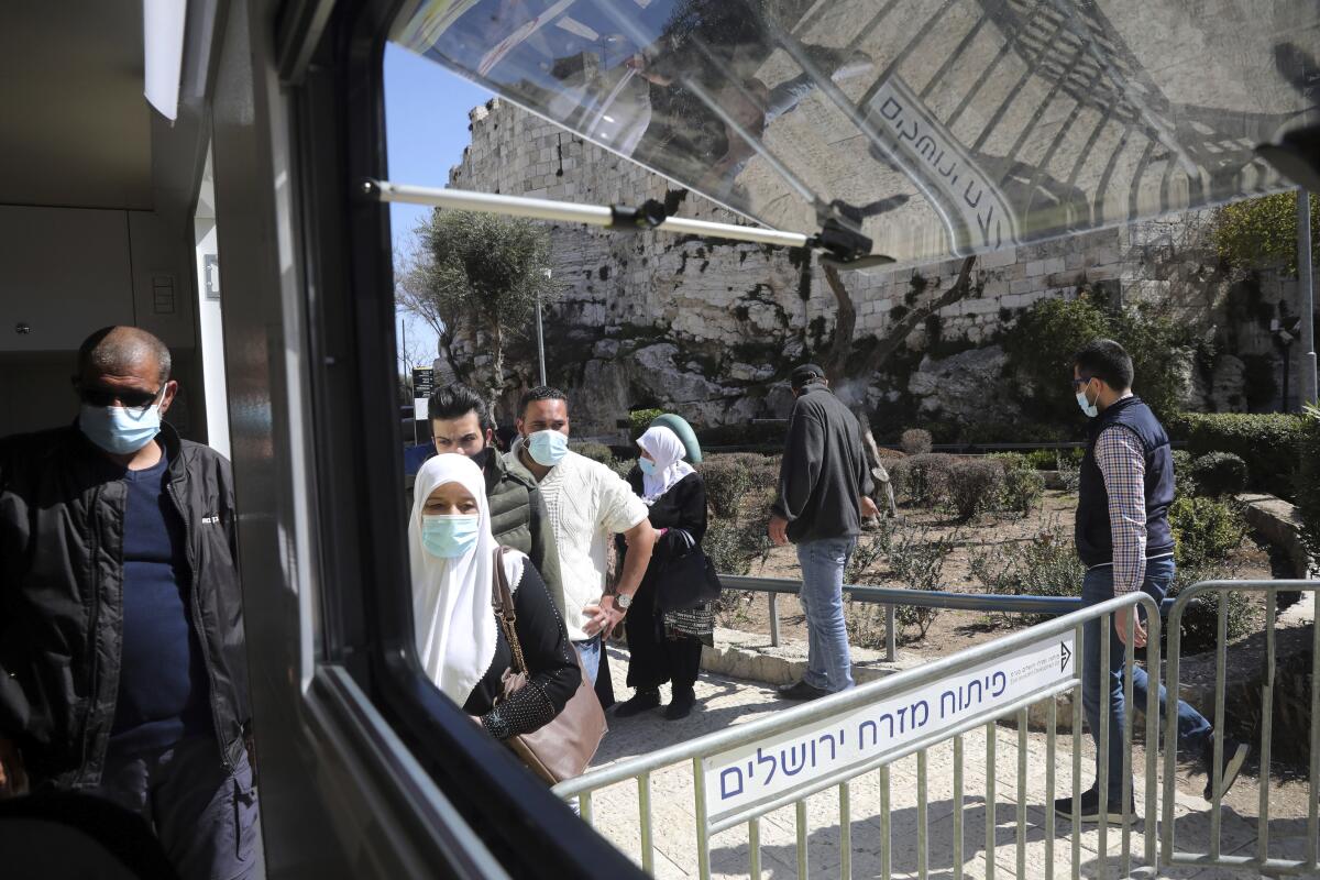 Palestinians wait to receive the COVID-19 vaccine outside of the Old City of Jerusalem.