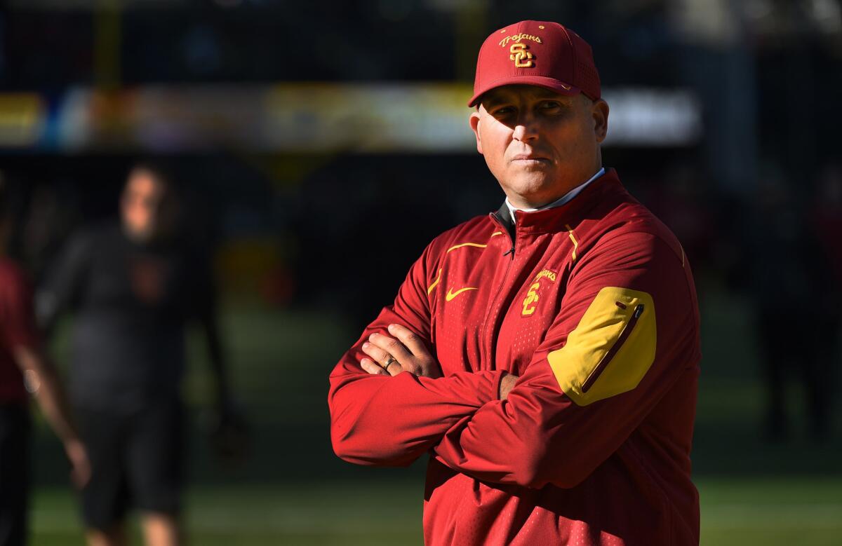 USC Interim Coach Clay Helton looks on as his team warms up before a game against Oregon.