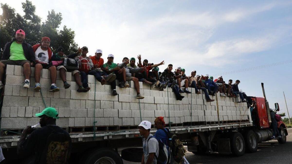 Some of the thousands of Central American migrants in the caravan get a lift to a camp on Oct. 30 in Juchitan de Zaragoza, Mexico.