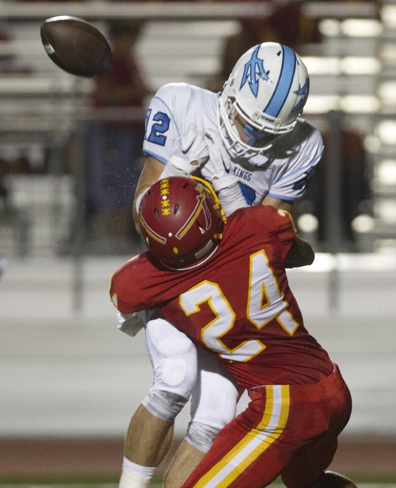 Corona del Mar High's Peter Bush has the ball jarred loose by Woodbridge's Jalen Gill (24).