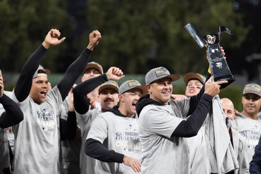 El mánager de los Yankees de Nueva York, Aaron Boone levanta el trofeo del campeonato de la Liga Americana luego del Juego 5 de la serie ante los Guardianes de Cleveland, el domingo 20 de octubre de 2024, en Cleveland. Los Yankees ganaron 5-2 para avanar a la Serie Mundial. (AP Foto/Sue Ogrocki)