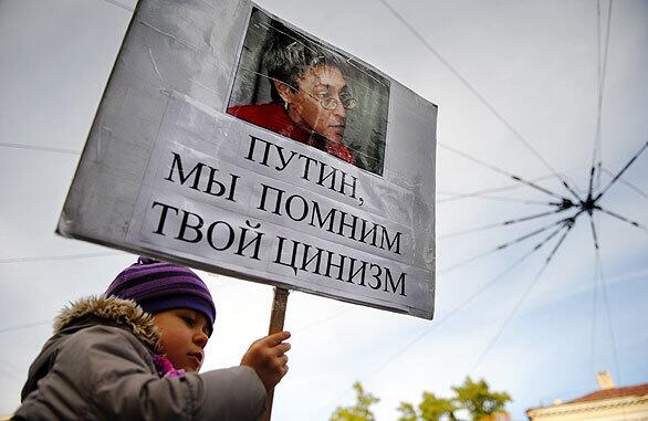 A child holds a sign during a rally by Russian human-rights activists in honor of Anna Politkovskaya. The Russian journalist, known for her criticism of President Vladimir Putin, was killed three years ago Wednesday. The slaying is still unsolved. The sign reads: "Putin we remember your cynicism."