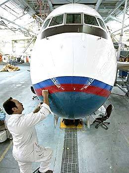 Claude Bomham puts the finishing touches on a Boeing 717, the smallest airliner in the company's fleet, at the Long Beach plant in September 2004. Boeing announced it would end production of the 717.