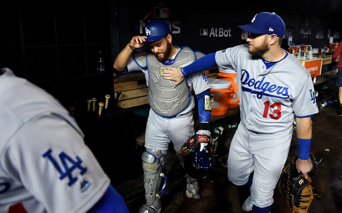 Dodgers catcher Russell Martin, left, gets a pat on the chest from Max Muncy after the Dodgers' win over the Nationals in Game 3 of the NLDS on Sunday.