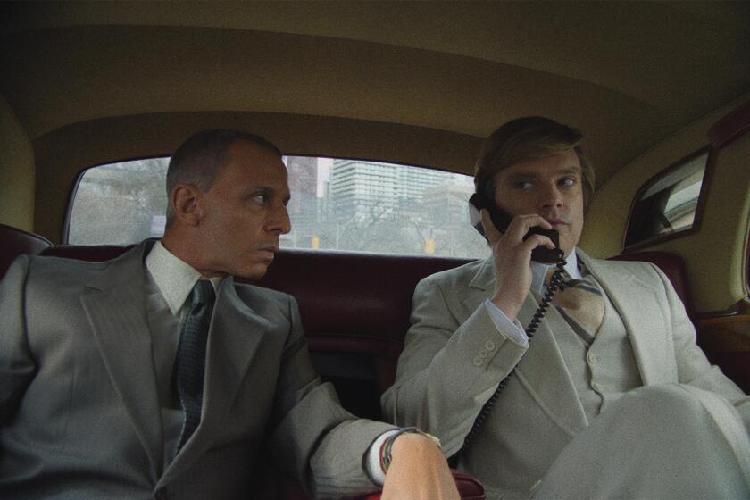 Two men drive in the back seat of a limo.