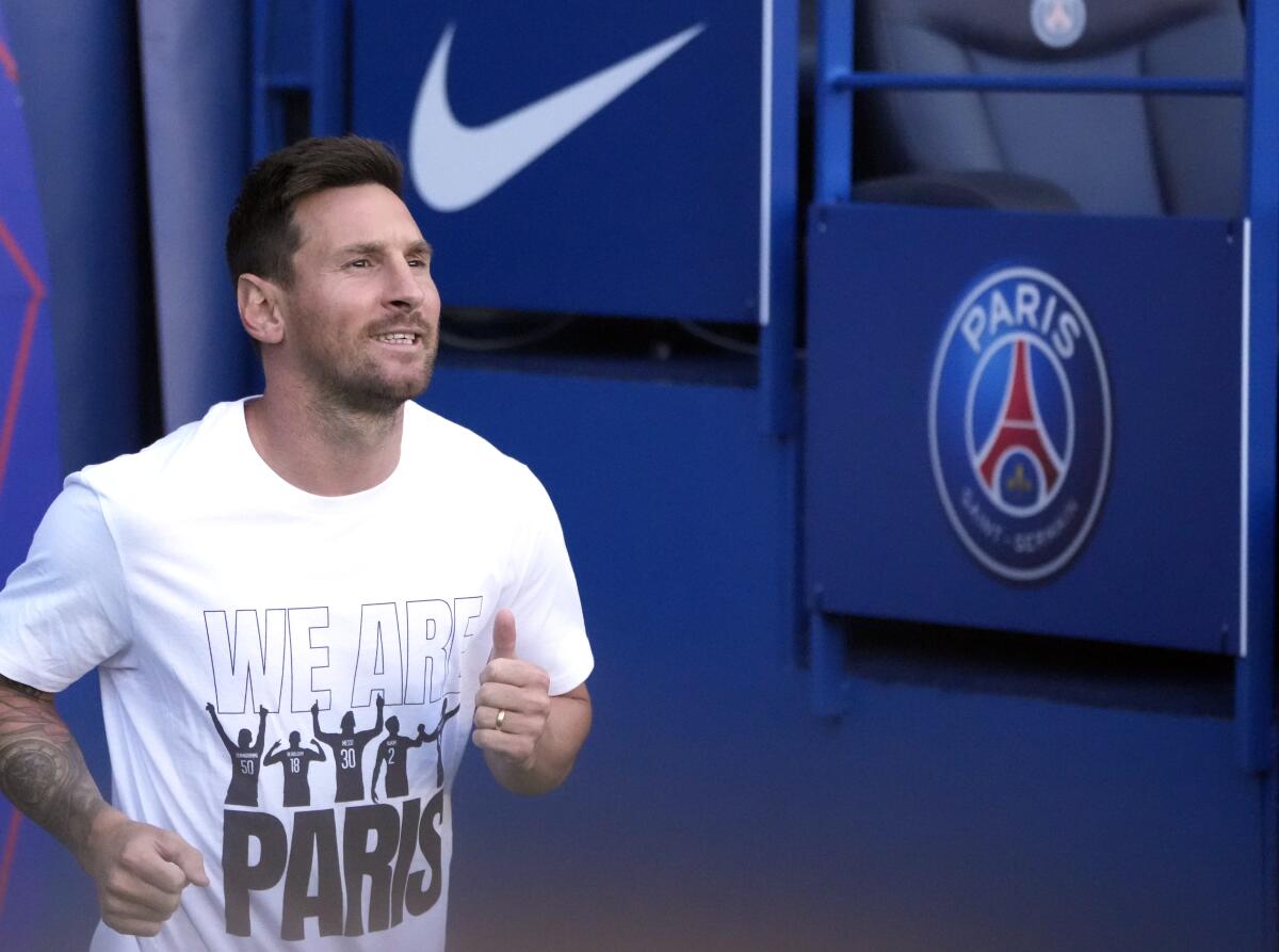 PSG's Lionel Messi runs onto the pitch in front of fans for the first time