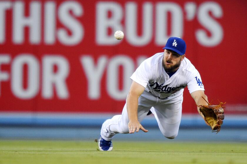 Dodgers outfielder Chris Heisey dives for a ball while playing against the Texas Rangers at Dodger Stadium on June 17.