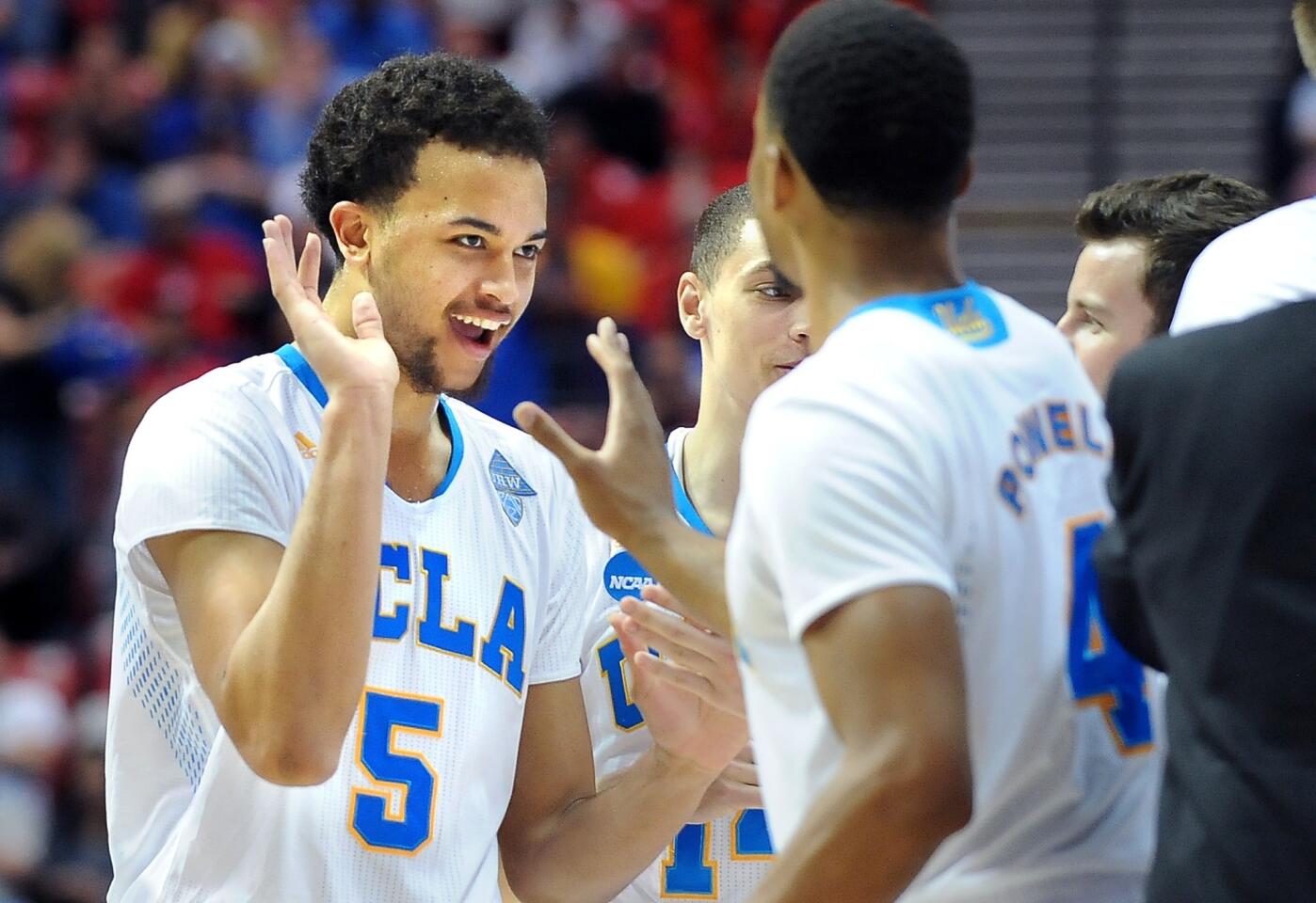 Bruins guards Kyle Anderson (5) and Norman Powell (4) celebrate after defeating Stephen F. Austin, 77-60, in the third round of the NCAA tournament on Sunday evening in San Diego.