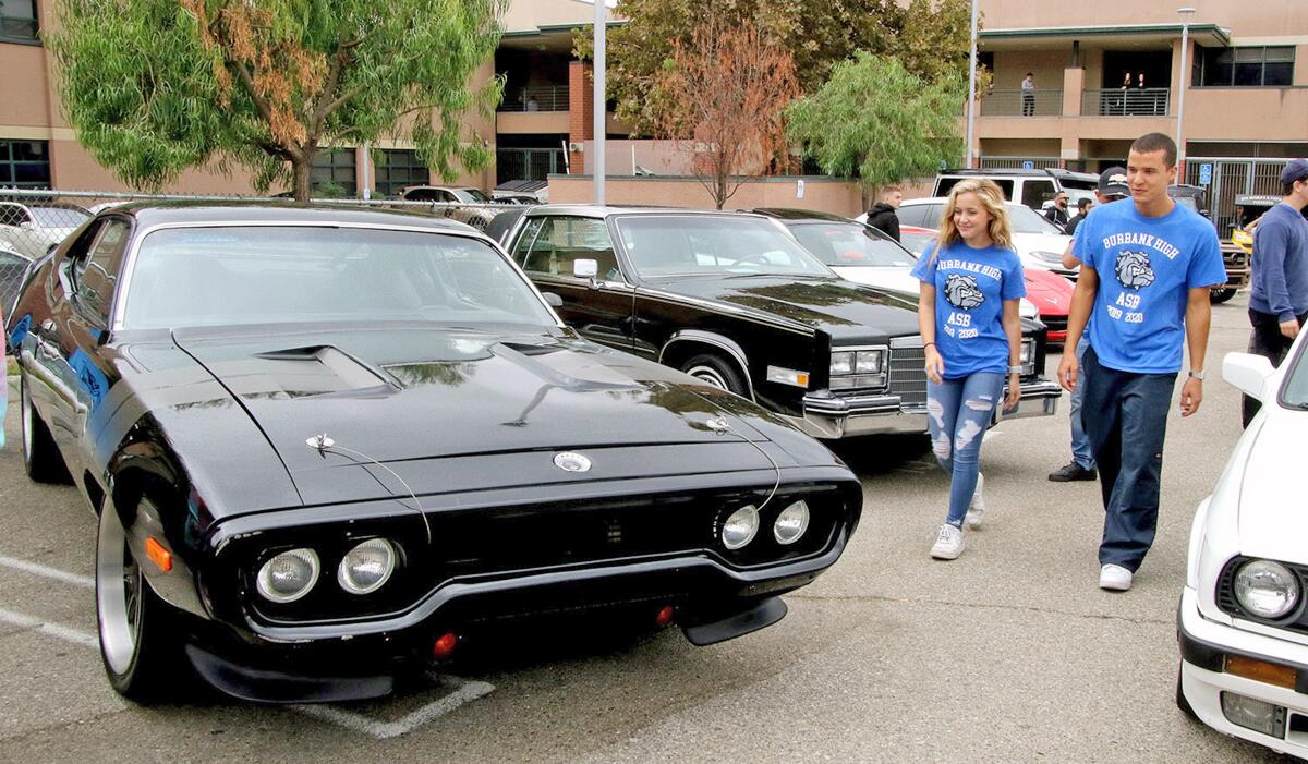 Visitors look over a 1971 Plymouth GTX that was in the movie "The Fast and the Furious" and on display at a car show at Burbank High School last Saturday.