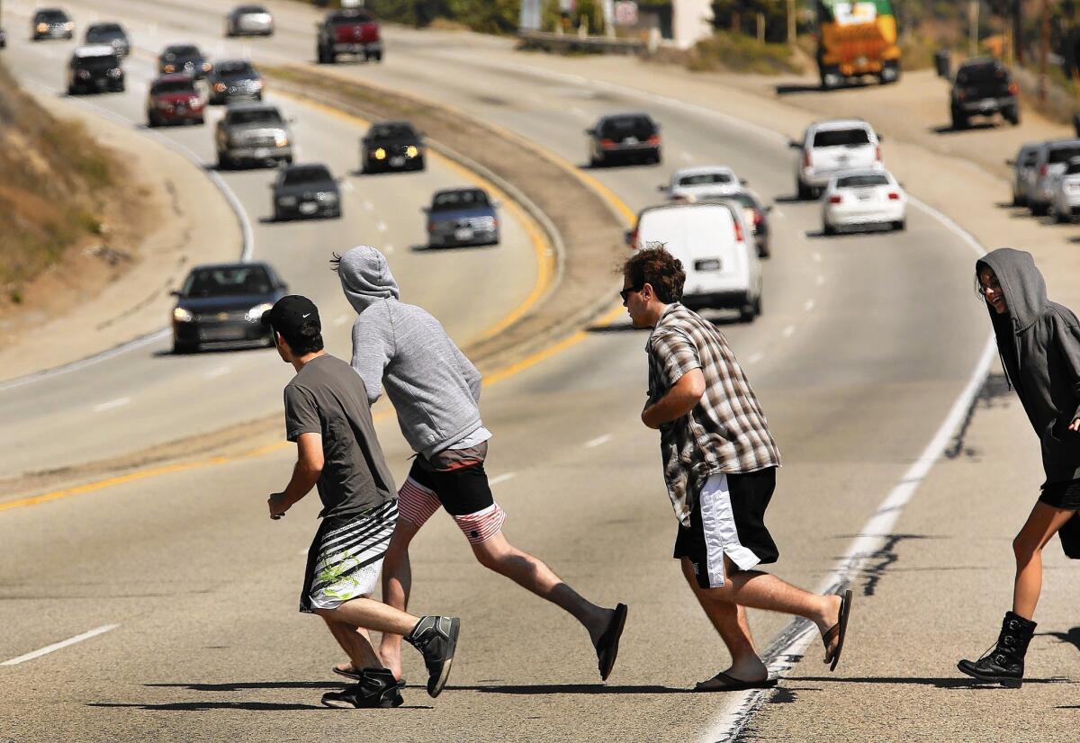 Pedestrians run to cross Pacific Coast Highway in Malibu as vehicles speed past in April. As of June, four people had died in 117 accidents in 2015 along the Malibu portion of PCH, according to the Los Angeles County Sheriff’s Department.