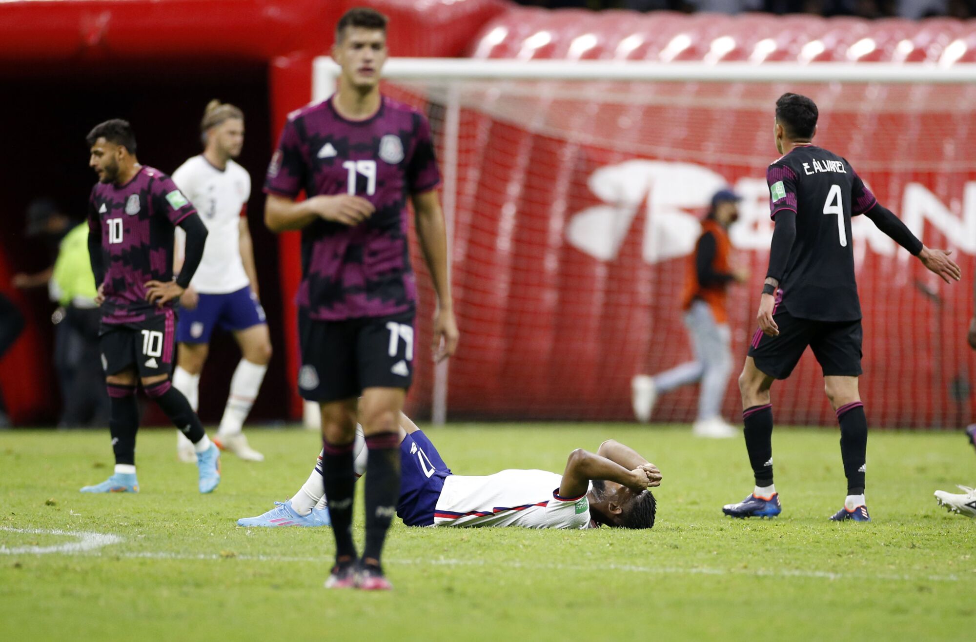 U.S. forward Jordan Pefok lies on the field exhausted after playing Mexico to a 0-0 draw.